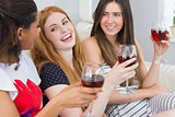Cheerful female friends with wine glasses enjoying a conversation