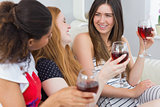 Cheerful friends with wine glasses enjoying a conversation