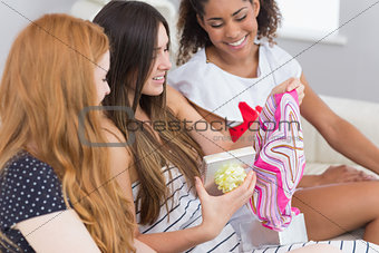 Cheerful young women surprising friend with a gift