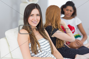 Portrait of a brunette with female friends chatting on sofa