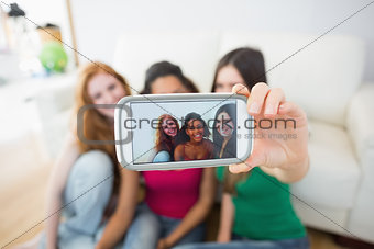 Friends photographing themselves with smartphone at home