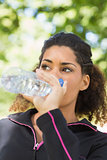 Close up of a tired woman drinking water in park