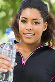 Close up portrait of a tired woman with water bottle in park