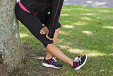 Low section of woman stretching her leg during exercise at park