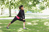 Healthy woman doing stretching exercise in park