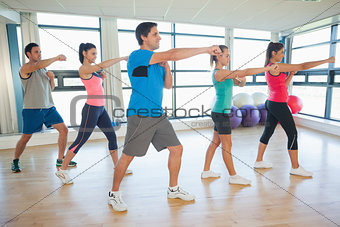 Sporty people doing power fitness exercise at yoga class