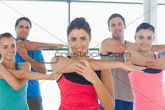 Portrait of sporty people stretching hands at yoga class