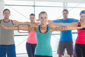 Portrait of sporty people stretching out hands at yoga class