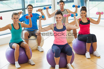 People exercising with dumbbells on fitness balls