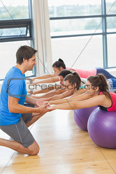 Trainer helping woman at fitness studio