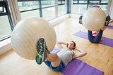 Class exercising with fitness balls at a bright gym