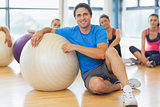 Instructor and fitness class with exercise balls at gym