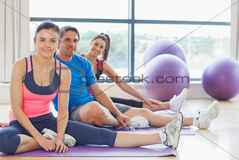 Fitness class and instructor sitting on exercise mats