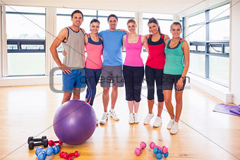 Full length portrait of fitness class at exercise room