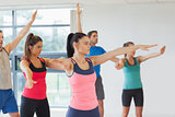 Sporty people stretching out hands at yoga class