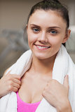 Close up of a smiling woman with towel around neck in gym