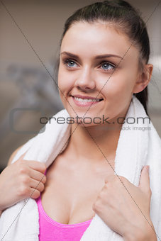 Close up of a woman with towel around neck in gym