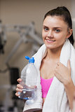 Portrait of a smiling woman with water bottle in gym