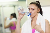 Close up portrait of a woman drinking water in gym