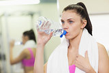 Close up of a woman drinking water in gym