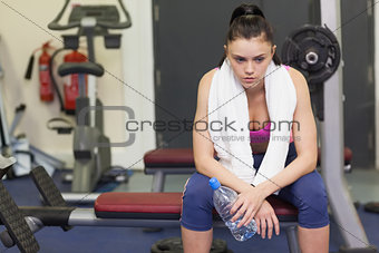 Tired and thoughtful woman in gym