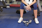 Low section of a tired and thoughtful woman in gym