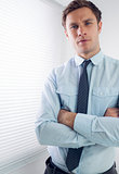 Elegant businessman with arms crossed in office