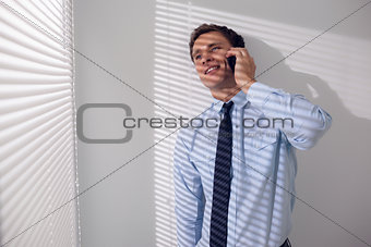 Smiling businessman using mobile phone