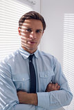 Elegant businessman with arms crossed in office