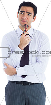 Thinking businessman holding glasses