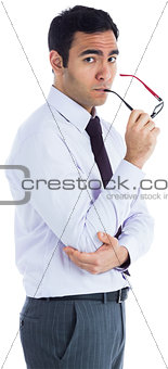 Unsmiling businessman holding glasses