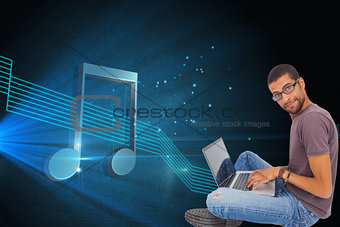 Composite image of man wearing glasses using laptop and looking at camera