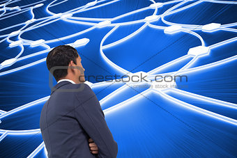 Composite image of unsmiling businessman with arms crossed