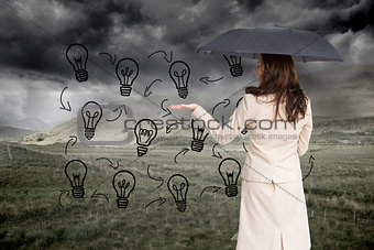 Composite image of businesswoman holding black umbrella