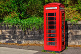 Typical red English telephone booth in the park