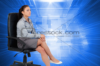 Composite image of portrait of a businesswoman sitting on an armchair