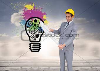 Composite image of architect with hard hat looking at plans