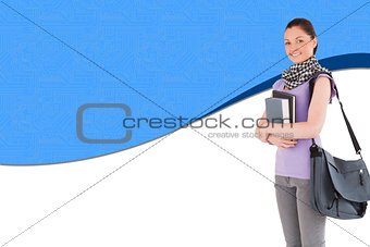 Composite image of student holding books and her bag while standing