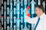 Composite image of businessman screaming into the handset