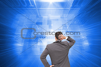 Composite image of businessman standing back to camera scratching his head