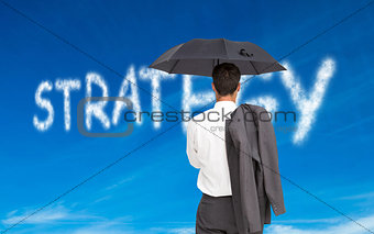 Composite image of businessman standing holding umbrella and jacket on shoulder