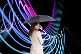 Composite image of rear view of businesswoman holding umbrella