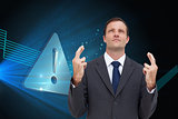 Composite image of businessman with fingers crossed is looking up