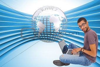 Composite image of man sitting using laptop and looking at camera