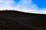 Group of trekkers hiking on a volcano hill