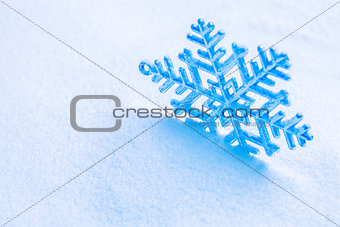 Snowflake on the snow. White xmas holiday background.
