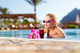 girl drinking coctail in the pool