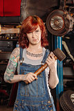 Female mechanic holding rubber mallet