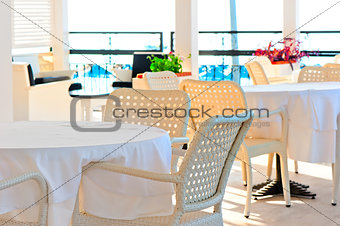 table covered with a white tablecloth and wicker chairs