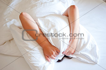 Woman with a pillow over her head